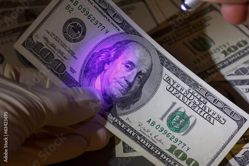 Photo: Dollar bill in uv light, fraud check Dollar bill in uv light, fraud check