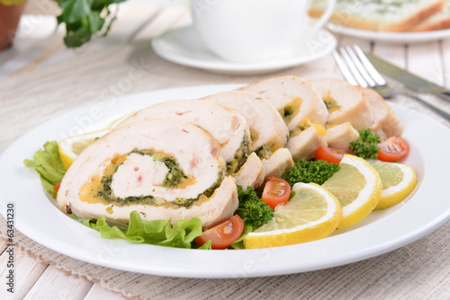 Photo: Delicious chicken roll on plate on table close-up Delicious chicken roll on plate on table close-up