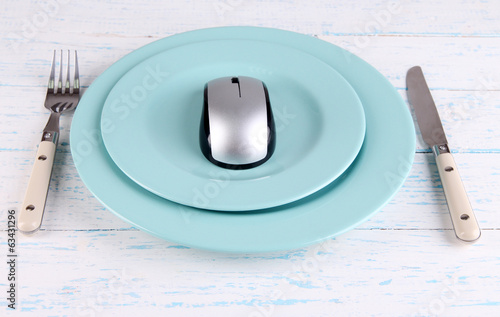 Photo: Computer mouse on plate with fork and knife on wooden Computer mouse on plate with fork and knife on wooden