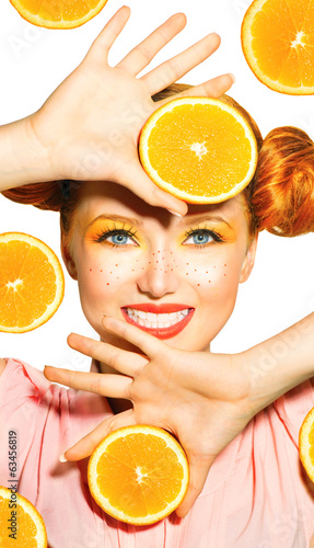 Photo: Beauty model girl takes juicy oranges. Freckles Beauty model girl takes juicy oranges. Freckles