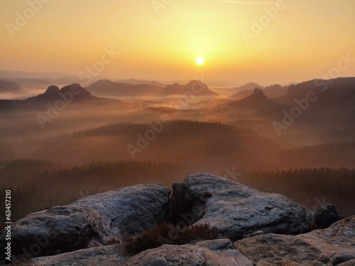 Photo: Sandstone peaks increased from fog, fog is colored to orange. Sandstone peaks increased from fog, fog is colored to orange.