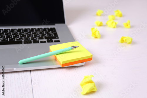 Photo: Office workplace with stickers and laptop on wooden desk Office workplace with stickers and laptop on wooden desk