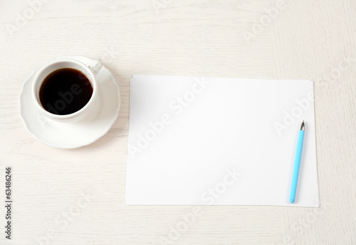Photo: Blank paper and pen on wooden table Blank paper and pen on wooden table