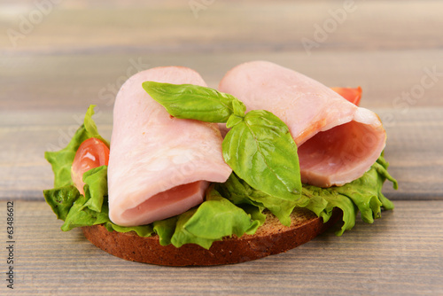 Photo: Delicious sandwich with lettuce and ham on table close-up Delicious sandwich with lettuce and ham on table close-up