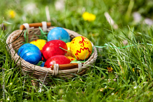 Photo: Easter eggs in basket on green grass. Easter eggs in basket on green grass.