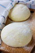 Dough balls covered with cloth on a wooden rustic kitchen board Dough balls covered with cloth on a wooden rustic kitchen board