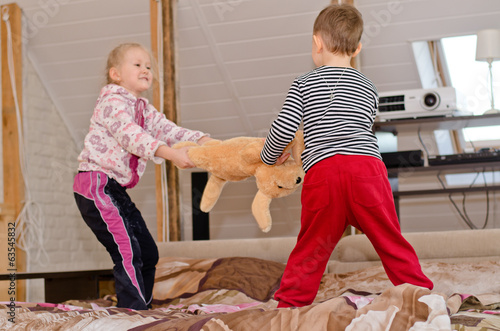 Photo: Cute brother and sister having a tug of war Cute brother and sister having a tug of war