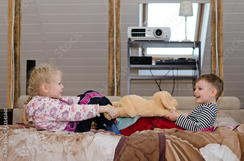 Photo: Brother and sister having a tug of war Brother and sister having a tug of war