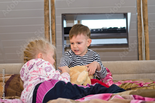 Photo: Brother and sister having a tug of war Brother and sister having a tug of war