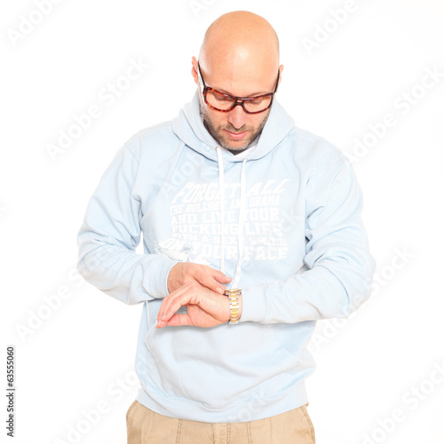 Photo: Mann mit Hoodie schau auf seine Uhr Mann mit Hoodie schau auf seine Uhr