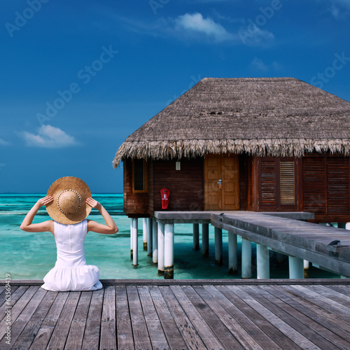 Photo: Woman on a beach jetty at Maldives Woman on a beach jetty at Maldives