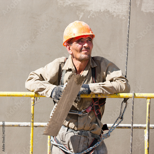 Photo: Plasterer worker looking at distance during construction works Plasterer worker looking at distance during construction works