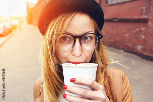 Photo: stylish woman in glasses drinking coffee in morning sunshine stylish woman in glasses drinking coffee in morning sunshine