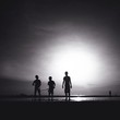 silhouette of three male friends walking on the beach silhouette of three male friends walking on the beach