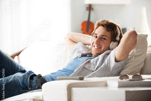 Photo: Guy with headphones on sofa Guy with headphones on sofa