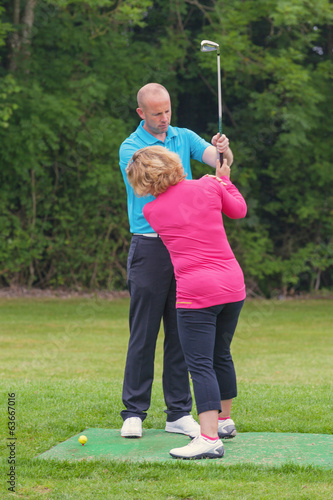 Photo: Golf pro correcting a lady golfers grip Golf pro correcting a lady golfers grip