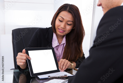 Photo: Businesswoman Showing Digital Tablet To Colleague Businesswoman Showing Digital Tablet To Colleague