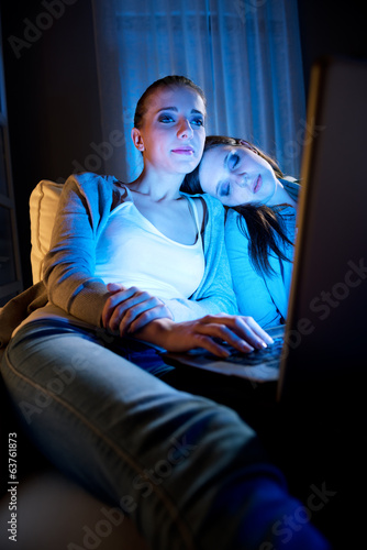 Photo: GIrlfriends on a sofa with laptop GIrlfriends on a sofa with laptop