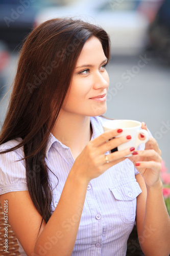 Photo: Woman drinking coffee and sitting outdoor Woman drinking coffee and sitting outdoor