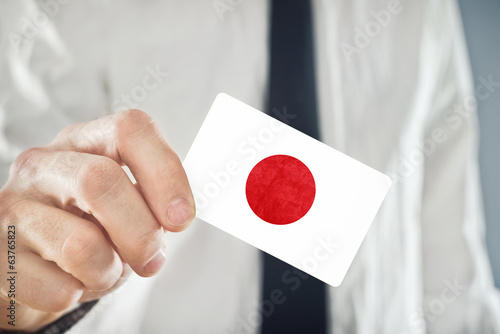 Photo: Japanese Businessman holding business card with Japan Flag Japanese Businessman holding business card with Japan Flag