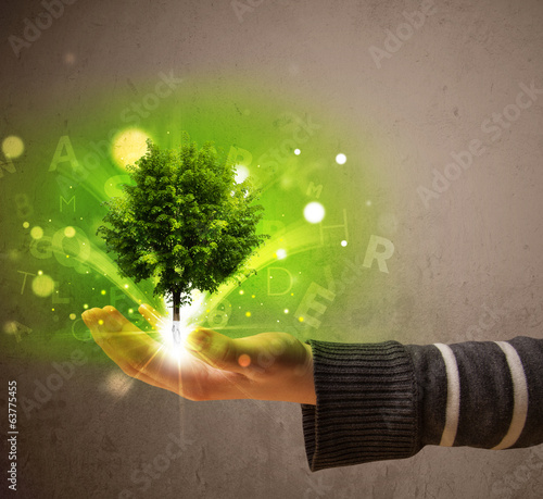 Photo: Glowing tree growing in the hand of a woman Glowing tree growing in the hand of a woman