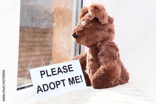 Photo: Toy-bear looking out window close-up Toy-bear looking out window close-up