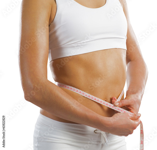 Photo: young athletic woman measuring waist young athletic woman measuring waist