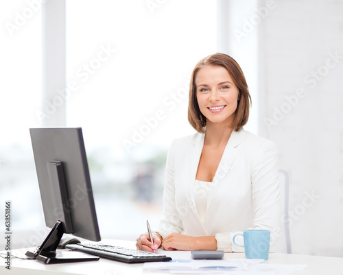 Photo: businesswoman with computer, documents and coffee businesswoman with computer, documents and coffee