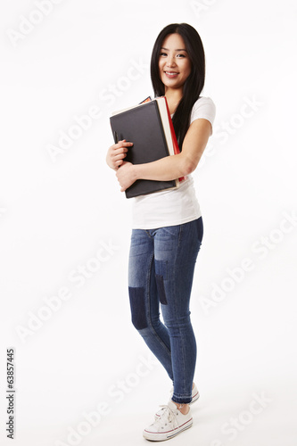 Photo: Studentin in weißen Shirt steht seitlich Studentin in weißen Shirt steht seitlich