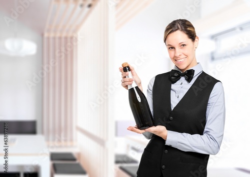 Photo: Waitress holding a bottle of champagne Waitress holding a bottle of champagne