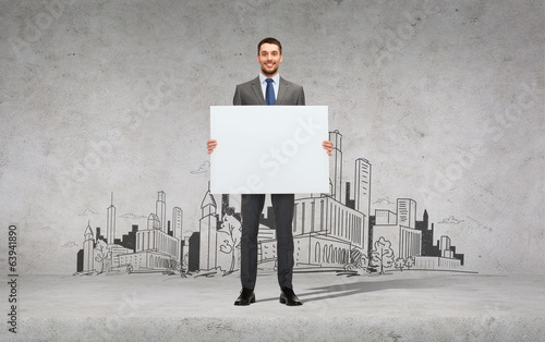 Photo: smiling businessman with white blank board smiling businessman with white blank board