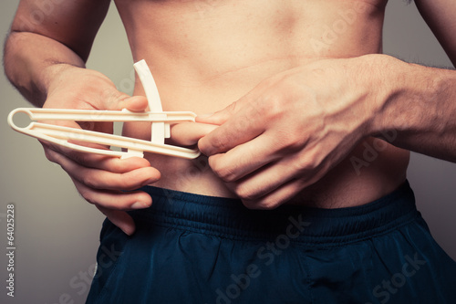 Photo: Young man measuring his body fat Young man measuring his body fat