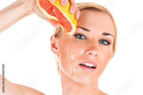 Photo: beautiful woman squeezes grapefruit juice on your face beautiful woman squeezes grapefruit juice on your face