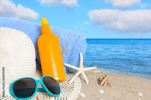 Photo: Straw hat, sunglasses, towel and starfish on sand beach. Straw hat, sunglasses, towel and starfish on sand beach.