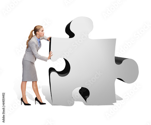 Photo: busy businesswoman pushing puzzle piece busy businesswoman pushing puzzle piece