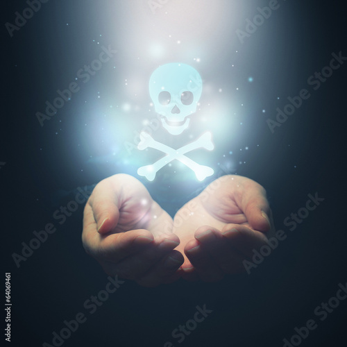 Photo: Female hands opening to light and skull Female hands opening to light and skull