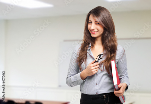 Photo: Smiling teacher standing in front of blackboard Smiling teacher standing in front of blackboard