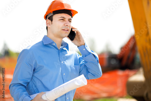 Photo: Engineer talking at the phone in a construction site Engineer talking at the phone in a construction site