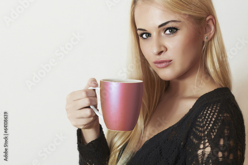 Photo: Beautiful woman drinking Coffee.Blond Girl with Cup of tea Beautiful woman drinking Coffee.Blond Girl with Cup of tea