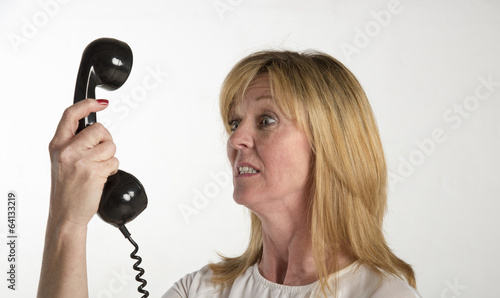 Photo: Angry woman shouting into a telephone Angry woman shouting into a telephone