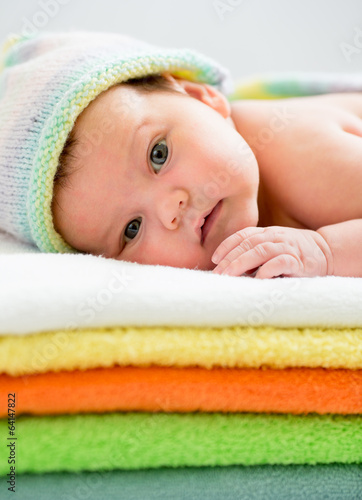 Photo: newborn baby girl lying on colourful towels newborn baby girl lying on colourful towels
