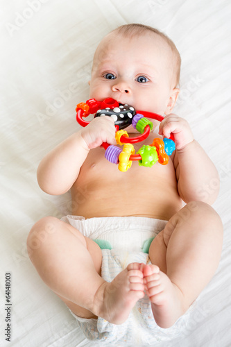 Photo: baby girl lying on back weared diaper with toy baby girl lying on back weared diaper with toy