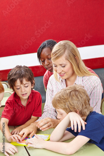 Photo: Schüler lösen Puzzle mit Lehrer in Schule Schüler lösen Puzzle mit Lehrer in Schule
