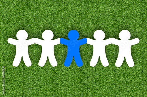 Photo: Paper team white people over grass background Paper team white people over grass background