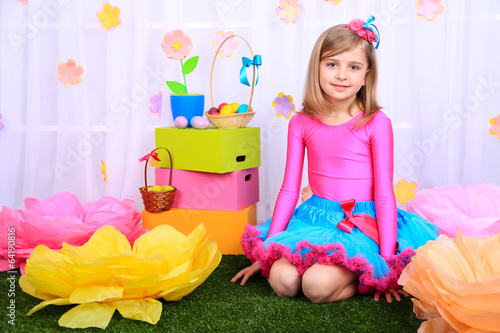 Photo: Beautiful small girl in petty skirt on decorative background Beautiful small girl in petty skirt on decorative background