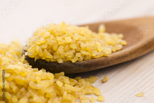 Photo: bulgur wheat in wooden spoon bulgur wheat in wooden spoon