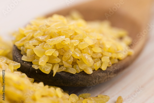 Photo: bulgur wheat in wooden spoon bulgur wheat in wooden spoon