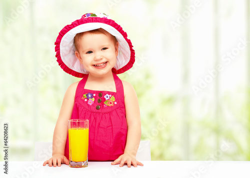 Photo: baby girl drinking orange juice in the summer baby girl drinking orange juice in the summer