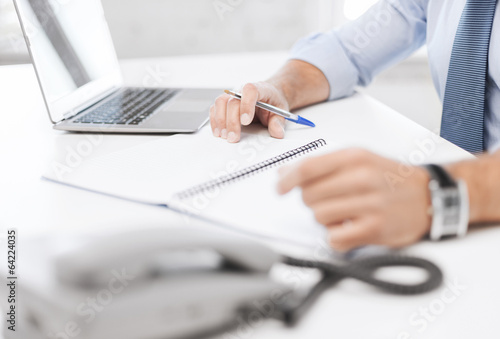 Photo: businessman writing in notebook businessman writing in notebook