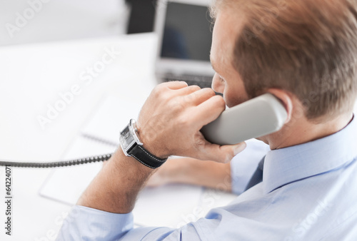 Photo: handsome businessman talking on the phone handsome businessman talking on the phone